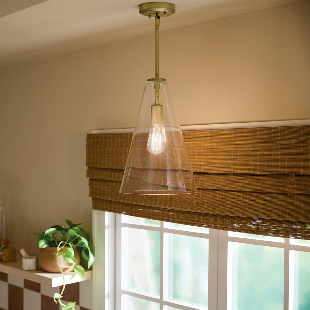 Kichler Everly clear glass pendant glowing over a kitchen window