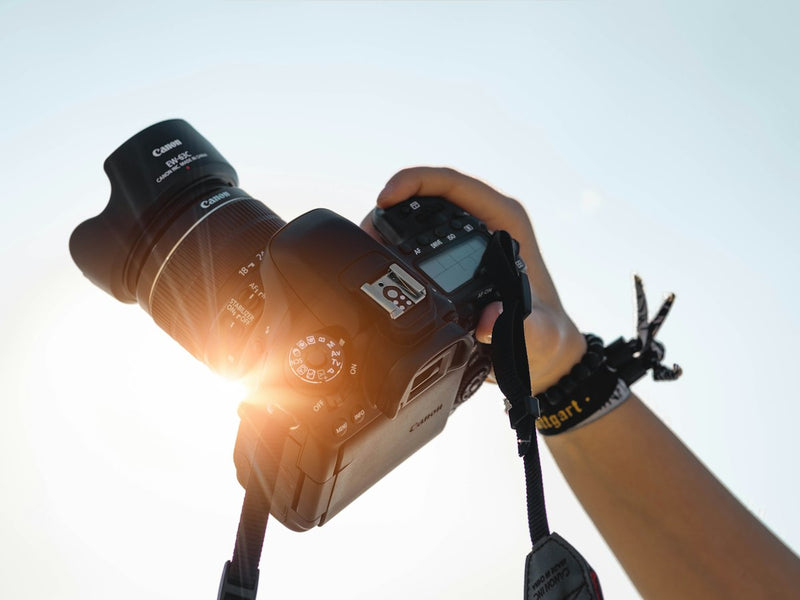 Hand holding a camera against the sun